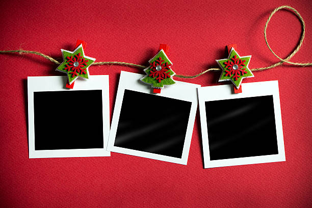 Christmas polaroid photo frames Christmas polaroid photo frames hanging on rope over red background 21st century photos stock pictures, royalty-free photos & images