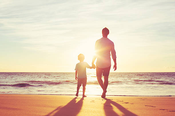 istock Father and Son Walking Together Holding Hands 496687442