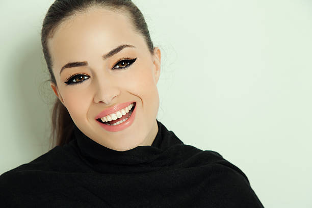portrait of a young smiling woman with elegant makeup, studio