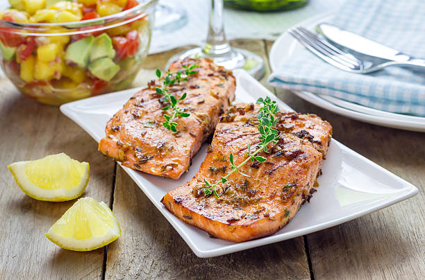 spice salmone alla griglia con salsa di mango-avocado su un piatto bianco - fish filet foto e immagini stock