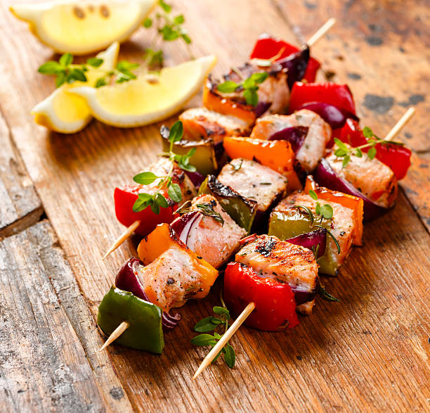 Grilled skewers of salmon and vegetables Skewers of grilled salmon, onions and peppers in herb lemon marinade kebab stock pictures, royalty-free photos & images