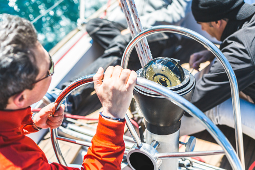 Stainless steel mooring equipment on the teak foredeck of the power boat.