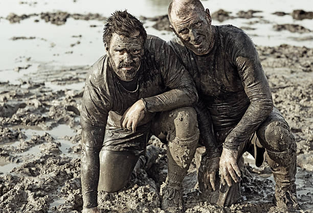 istock male friends posing in mud during obstacle run 496701280