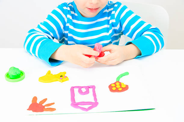 istock little boy playing with clay dough, education and daycare 496702034