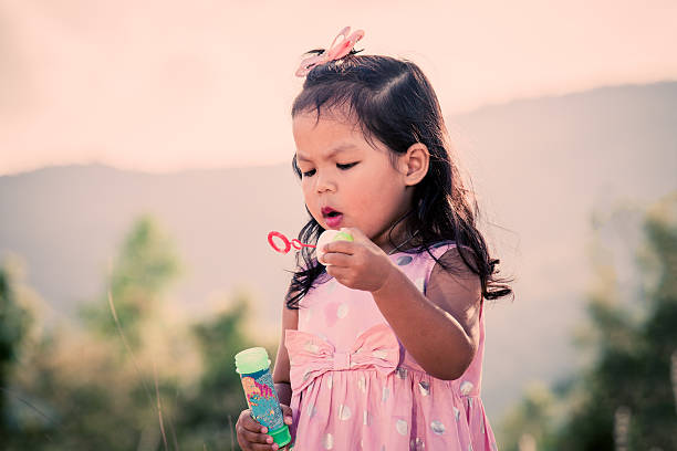 istock Child cute little girl blowing a soap bubbles 496703204