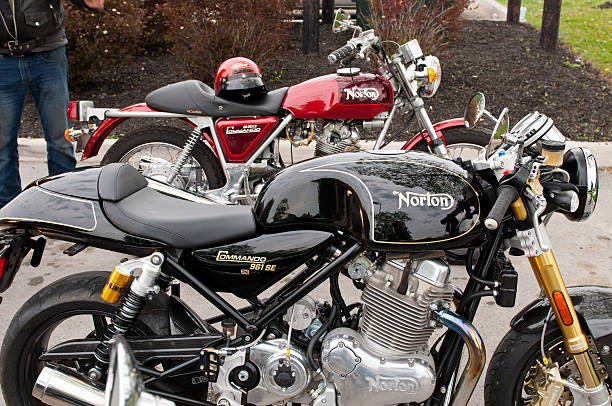 Norton Commando new and old - Side View Port Colbourne, Ontario, Canada - June 8, 2014: A side view of two Norton Commando Motorcycles.  A red 1973 Norton 850 and a black 2013 Norton 961 parked outside in a parking lot in Port Colbourne. norton brand name stock pictures, royalty-free photos & images