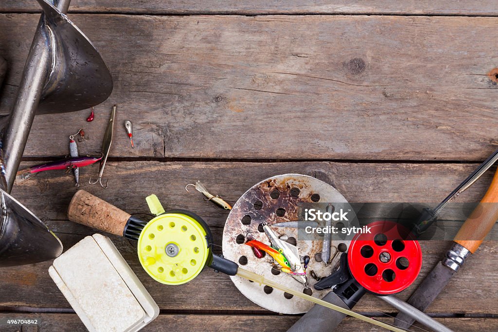 closeup ice fishing tackles and equipment frame from ice fishing rods, tackles and equipment on wooden timber background for design, print and advertisements 2015 Stock Photo