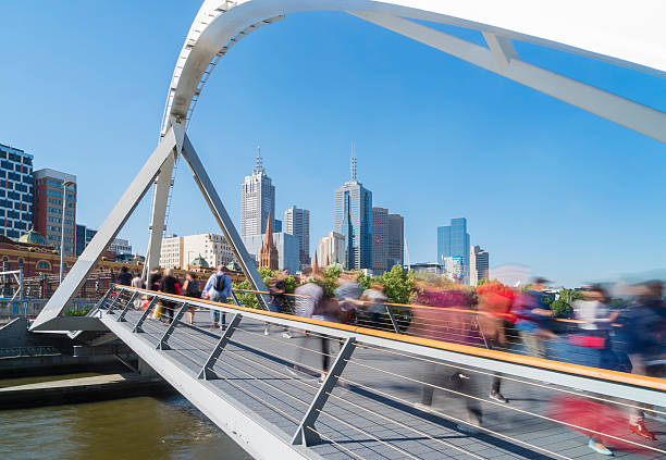 People walking across the Southgate footbridge in Melbourne View of people in motion blur walking across the Southgate footbridge in Melbourne during daytime yarra river stock pictures, royalty-free photos & images