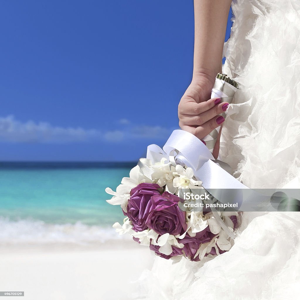 Wedding bouquet in bride's hand Wedding bouquet in bride's hand on beach Beach Stock Photo