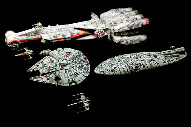 Attacking Armada Vancouver, Canada - July 30, 2014: The Tantive IV Rebel Blockade Runner and a Rebel Blockade Runner, with the Millenium Falcon and X-Wings from the Star Wars movie franchise on a black background. The Tantive IV was the flagship of Princess Leia at the beginning of Star Wars, Episode IV: A New Hope. The models were made for the X-Wing minature game for Fantasy Flight Games. armada stock pictures, royalty-free photos & images