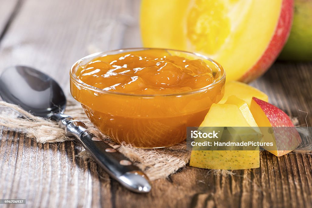 Portion of Mango Jam Homemade Mango Jam with some fresh fruits (on wooden background) Mango Fruit Stock Photo