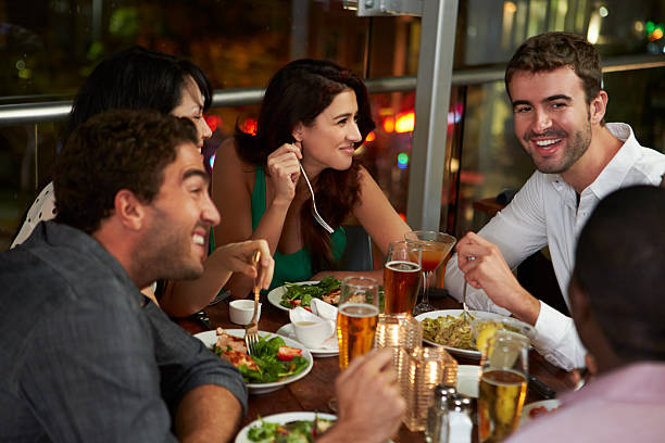 istock Group Of Friends Enjoying Evening Meal In Restaurant 496707577