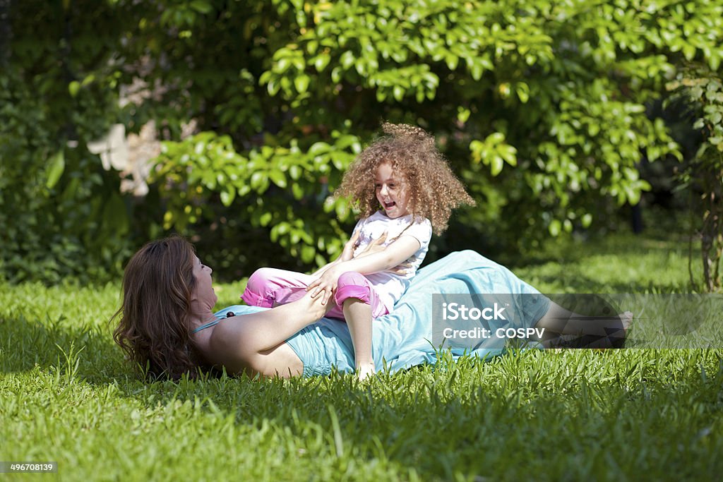 Mother and daughter Mother and daughter are enjoying on grass at park Adult Stock Photo