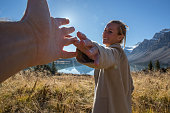 Cheerful couple walking in meadow holding hands