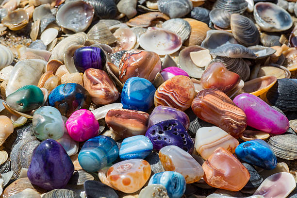 istock Multicolored agates with seashells on the beach 496711562