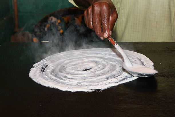 Dosa is a fermented crepe made from rice batter and black lentils, in South Indian Andhra Pradesh, Karnataka, Tamil nadu, Kerala. Making hot dosa in traditional rural kitchen. Sambar, coconut chutney Sri Lanka
