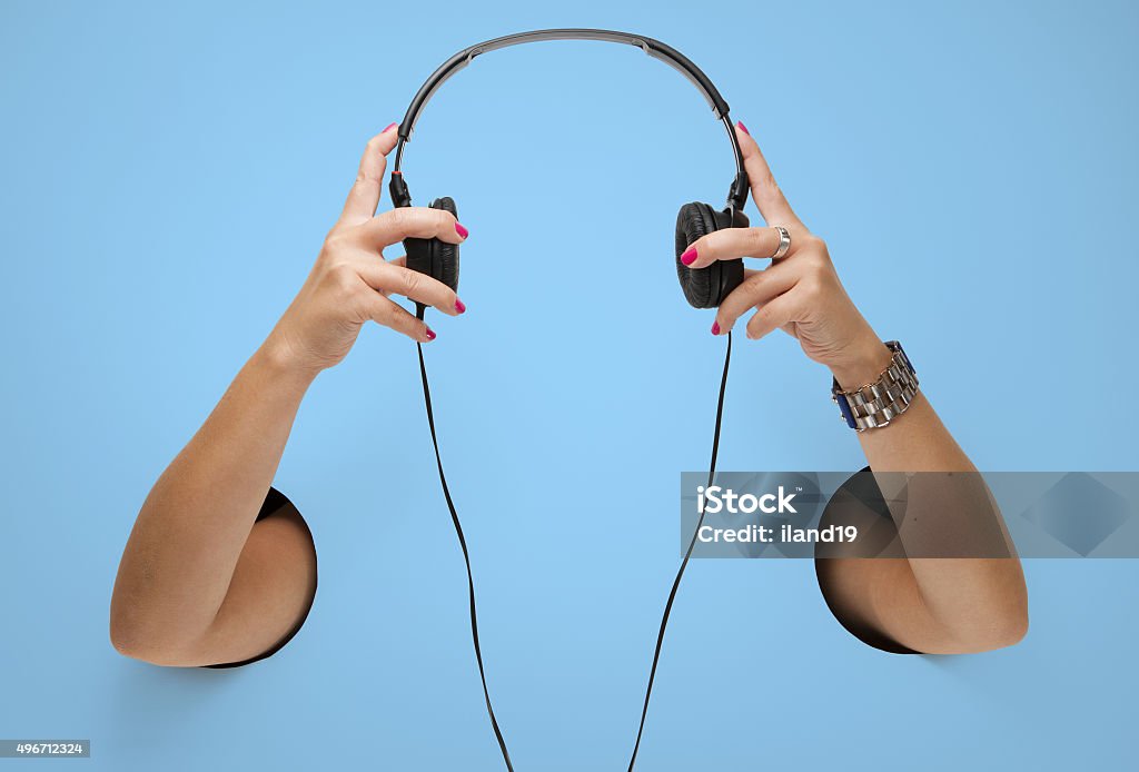 The headphones in a female hands through the holes Hole Stock Photo