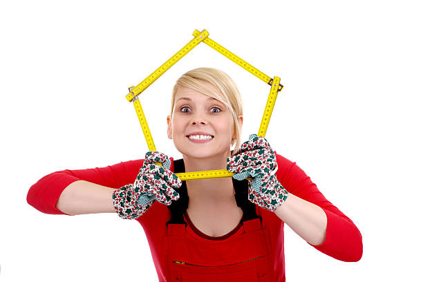 istock blonde with construction tape measure in a red jumpsuit 496718117