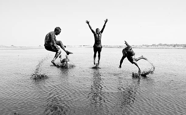 istock Group of friends playing in a mud lake 496719647