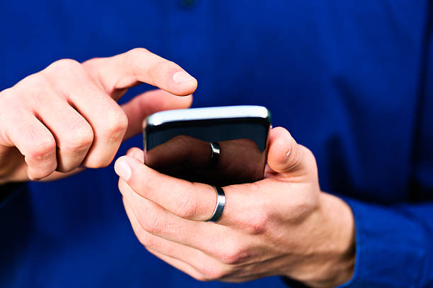 istock Male hands tapping cellphone screen or keyboard 496719827