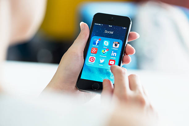 социальные медиа apps на apple iphone 5s - iphone google holding telephone стоковые фото и изображения