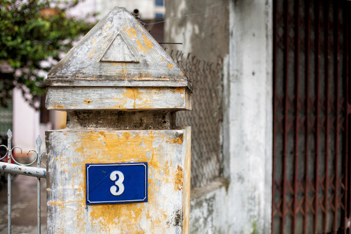 Concrete pillar with the number three on a street in Hue, Vietnam