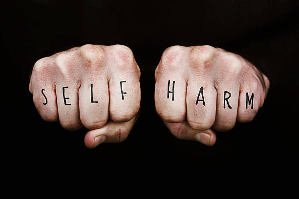 Self Harm Self Harm written across the knuckles of two clenched fists.  Note that the font design is my own. self harm photos stock pictures, royalty-free photos & images