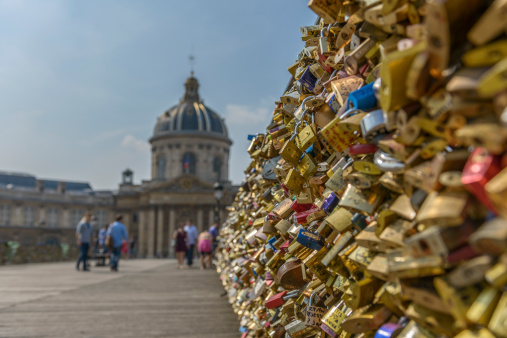 Love padlocks at Pont des Arts with French Institute in the background in Paris, France