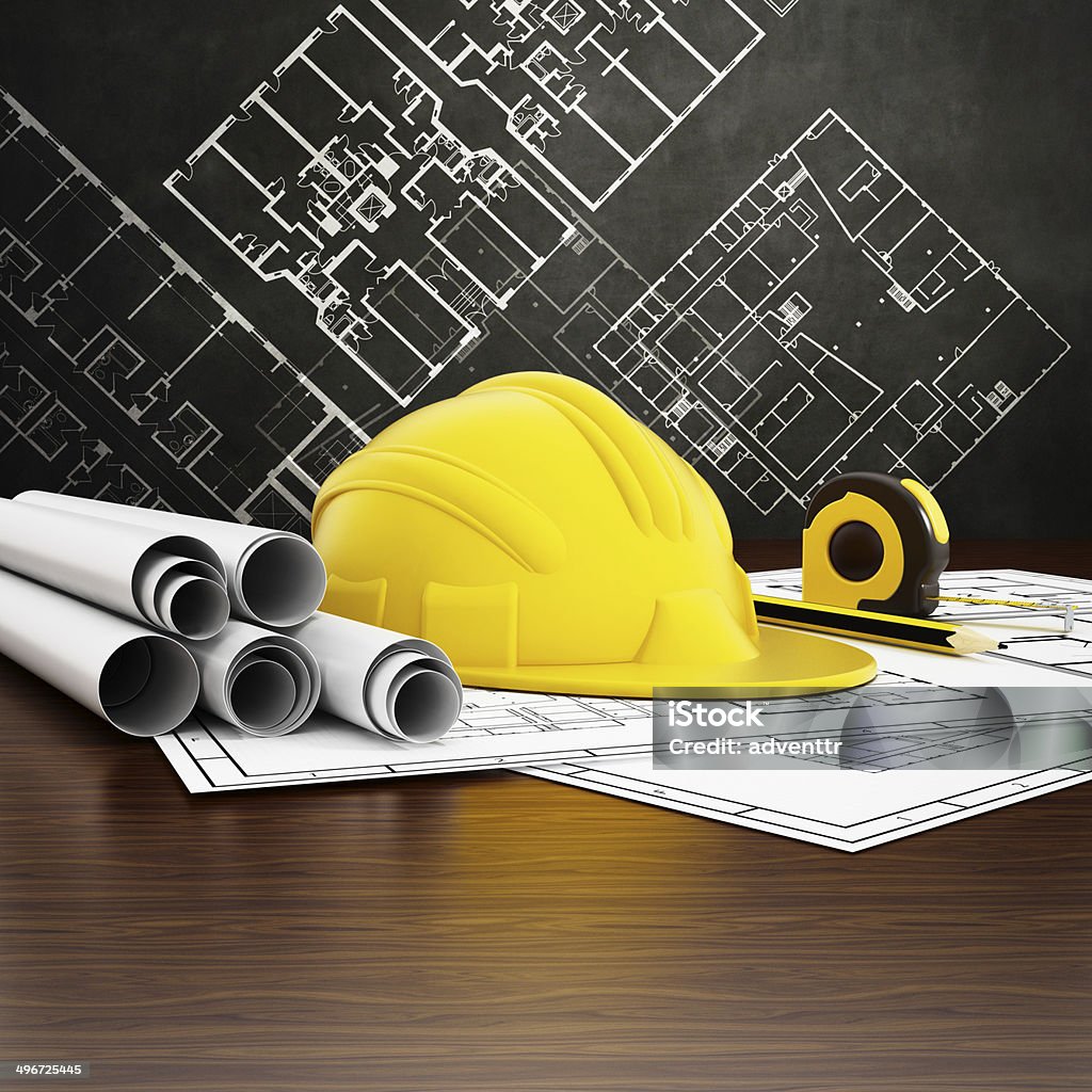 Engineering Hardhat, construction plans, measuring tape and pencil standing on wooden reflective surface with architectural drawings on the background. Architect Stock Photo