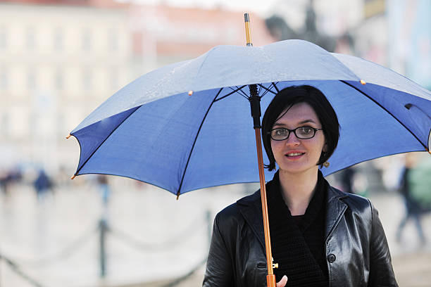 istock woman on street with umbrella 496725538