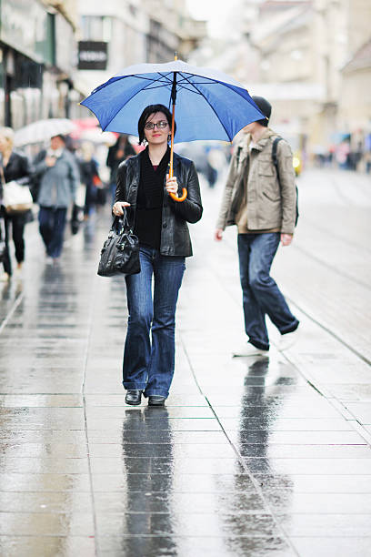 istock woman on street with umbrella 496725840