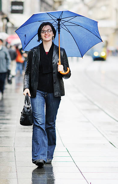 istock woman on street with umbrella 496725876