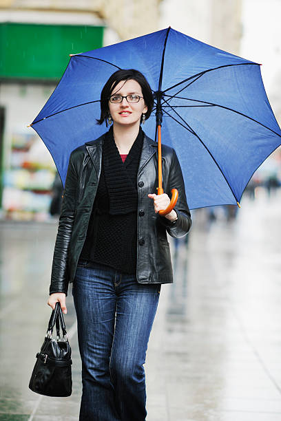 istock woman on street with umbrella 496725952