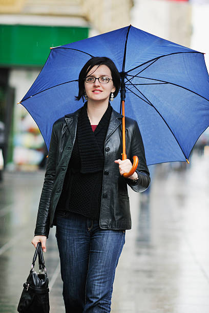 istock woman on street with umbrella 496726036
