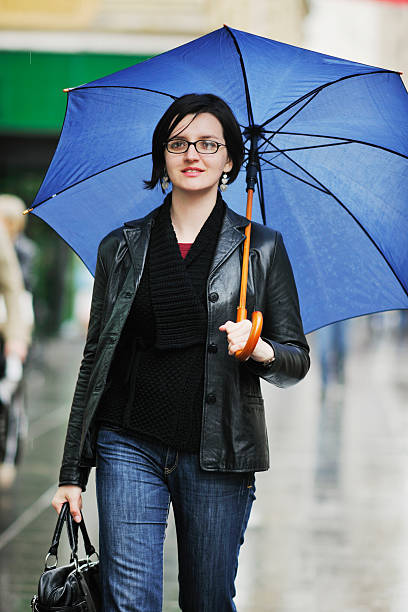 istock woman on street with umbrella 496726166