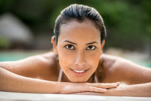 Beautiful Asian woman in the swimming pool at the spa enjoying the hydrotherapy