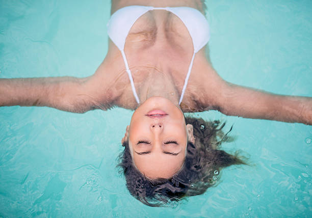 piękna kobieta w basenie w spa - floating on water women swimming pool water zdjęcia i obrazy z banku zdjęć