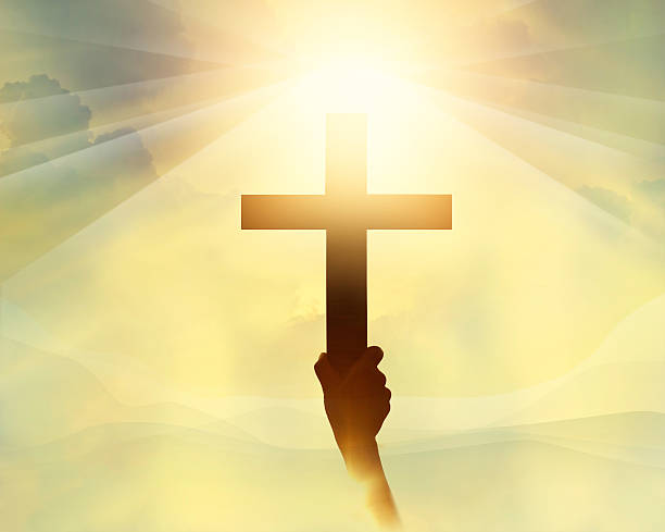 istock Silhouette the cross in hand, religion symbol in light 496731468