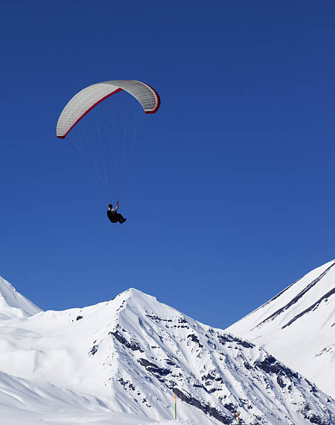 istock Paraglider in sunny snowy mountains at nice day 496732232