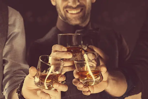 Photo of Men drinking whiskey, close up of glasses and hands