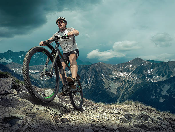 istock Man in helmet stay on the bicycle around mountains. 496734030