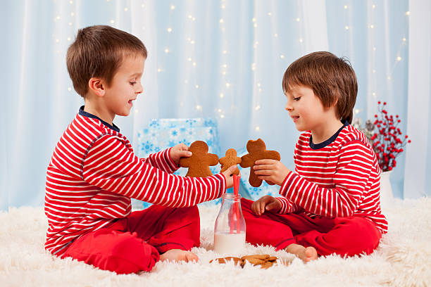 dos niños felices comiendo cookies en navidad y beber leche - milk milk bottle drinking straw cookie fotografías e imágenes de stock