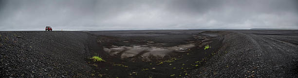 istock car on the road through black dessert in iceland 496763112