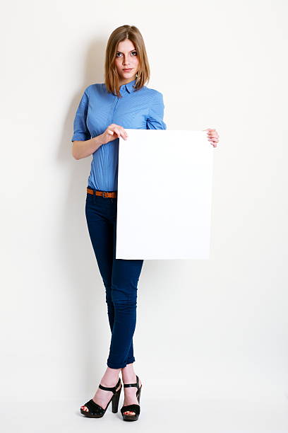 istock woman holds out a big blank card 496766812