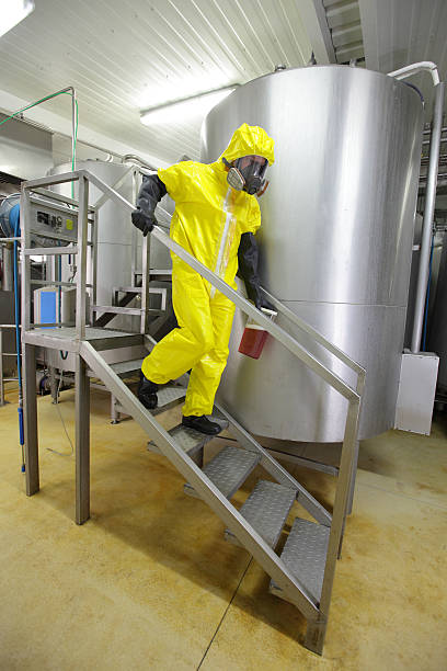 istock technician in protective coveralls with sample of fluid 496767036