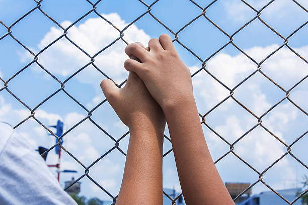 istock asian girl hand hold jail 496767890