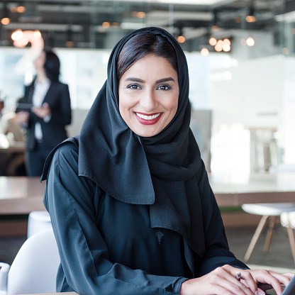 Atractiva mujer de negocios usando árabe hiyab sonriendo a la cámara photo