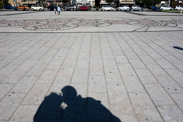Pozzuoli, Italy - November 7, 2015: Couple kissing shadow on the street, photo taken in Pozzuoli, Bay of Naples, Italy. Some people walking in background. 
