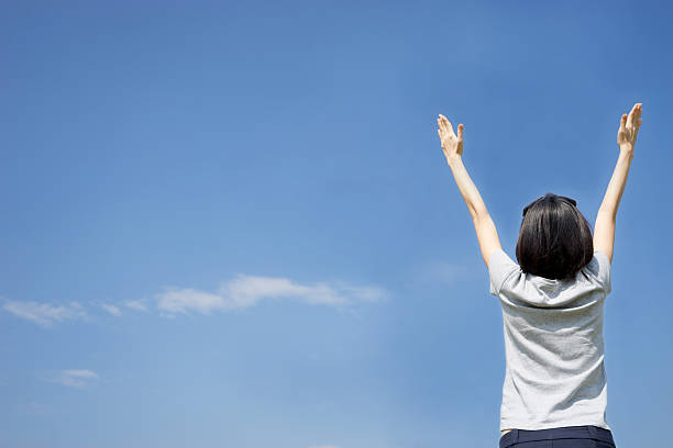 istock female with arms out spread standing outdoors 496771940