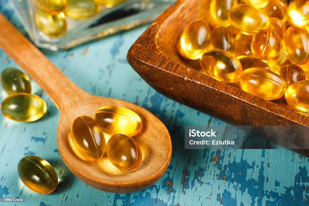 Cod Liver Oil Capsules Cod Liver Oil Capsules on wooden spoon Omega-3 Stock Photo